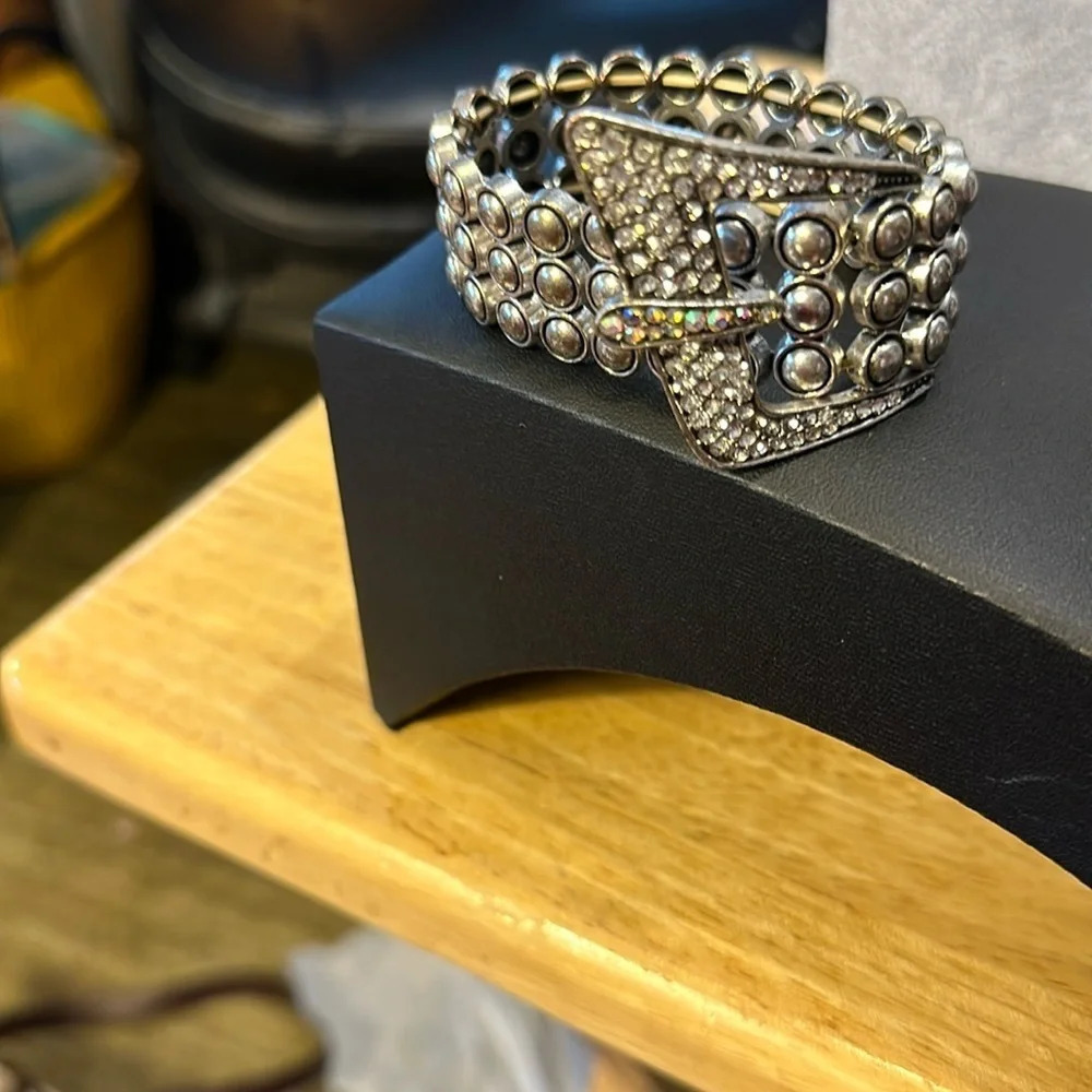 Bracelet, silver tone it looks like a belt buckle. The belt buckle has bling​